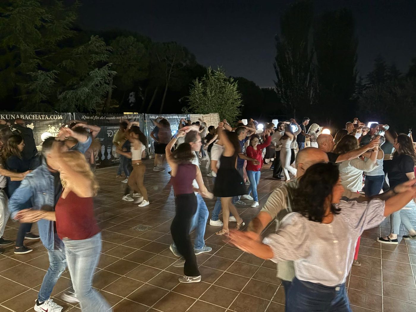 Alumnos de Hakuna Bachata bailando salsa en un social nocturno en la terraza